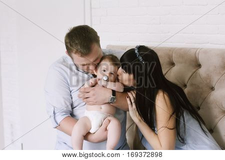 happy family consisting of mom and dad's baby boy. happy family relationships. mother entertains a child, his father holding him in his arms.