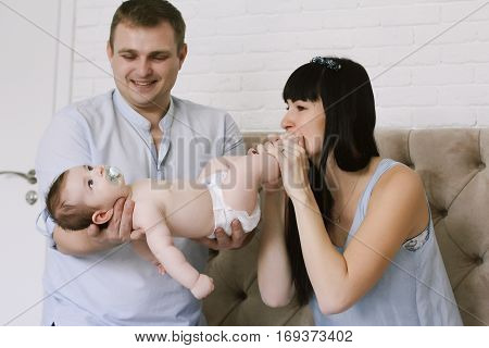 happy family consisting of mom and dad's baby boy. happy family relationships. mother entertains a child, his father holding him in his arms.