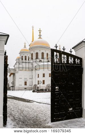 Opened gate and pathway to temple in snowy winter day. Orthodox temple. Novo-Tikhvinsky women monastery, Ekaterinburg.