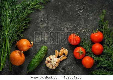 Raw vegetables on a dark black stone background top view. Copy space above.
