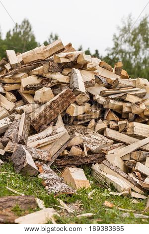 Firewood background - chopped firewood on a stack. Dry chopped firewood logs in a pile. Nature abstract background with stack of firewood.