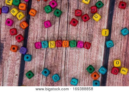 Announce - Word Created With Colored Wooden Cubes On Desk.