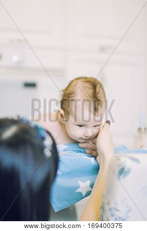 small child learns to help parents keep his head. baby lying on a blue diaper in a star. parental support.