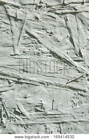 Bumps ridges and cracks in a worn piece of painted particle board