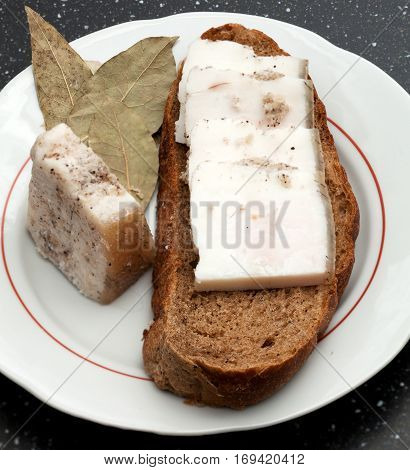 Lard on rye bread on a plate close-up