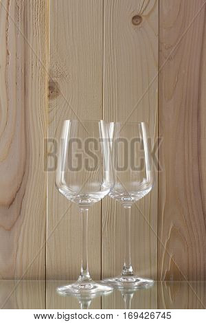 two transparent glass standing on a glass stand with a wooden background