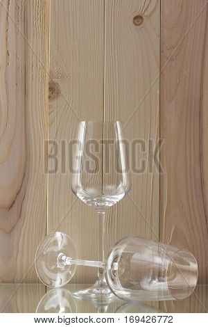 two transparent glass standing on a glass stand with a wooden background