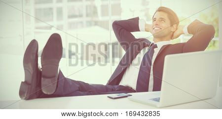 Successful businessman in his office relaxing with his feet on his desk