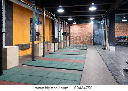 A row of horizontal bars and boxes for exercices in a cross-fit gym
