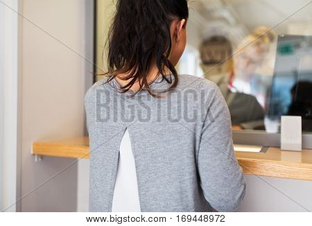 people and finance concept - customer at bank office window or currency exchanger