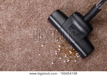 Vacuuming carpet with vacuum cleaner. Dirt on the rug. Housework service. Close up of the head of a sweeper cleaning device.