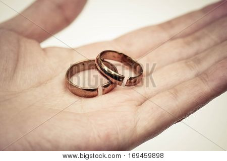 Hand holding broken rings / Divorce cond ending relationship concept