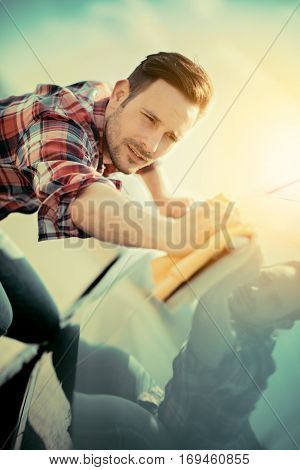 Man worker polishing car on a car wash outdoors.