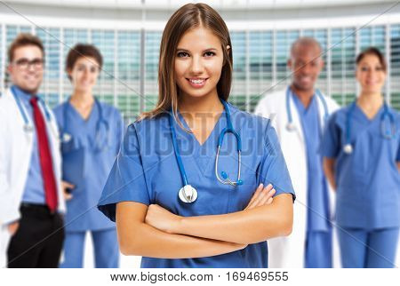 Portrait of a smiling young doctor in front of a group of medical workers