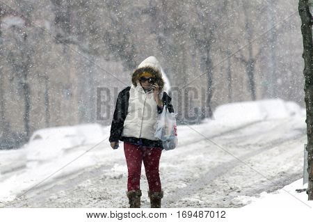 BRONX NEW YORK - JANUARY 7: Woman using cel phone during snow storm. Taken January 7 2017 in New York.