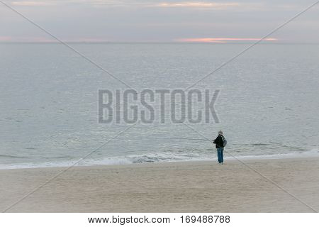 Man fishing at the beach of the Sea of Cortez in Mexico at sunrise.