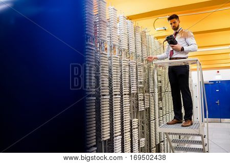 Technician using digital cable analyzer in server room