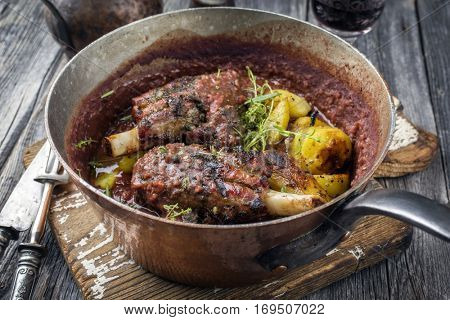 Lamb Knuckles with Fried Potatoes in Burgundy Sauce in Casserole