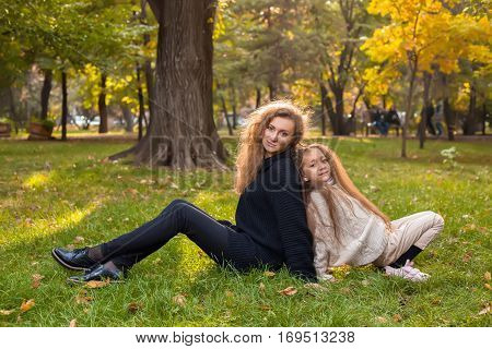 Mother With Daughter Seven Years Old In Autumn Park At Sunset