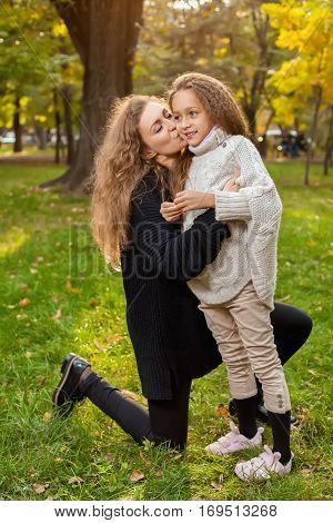Mother With Daughter Seven Years Old In Autumn Park At Sunset