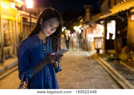 Woman using cellphone at night