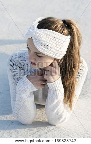 Young attractive woman wearing white knitted sweater and ear warmer turban. 