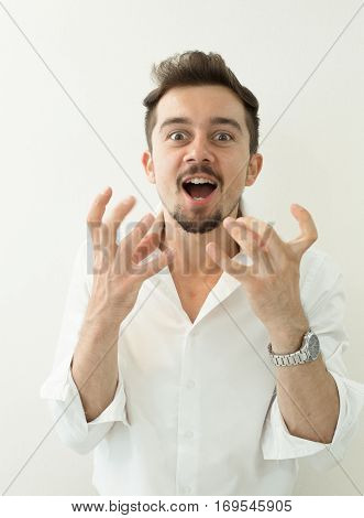 Portrait of young angry man. Angry shouting man at somebody. Screaming man gesturing with hands on white background. Screaming gesturing man. Oh my God.