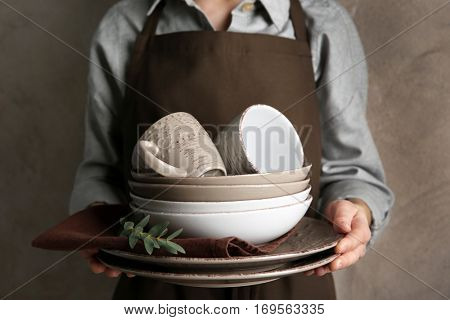 Female hands holding pile of dishware, closeup