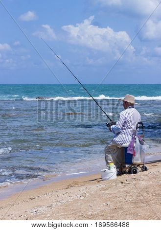 Elderly Man Fishing With A Fishing Rod