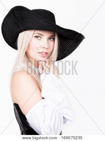 sexy woman with hourglass figure dressed in black leather corset with wide-brimmed hat.