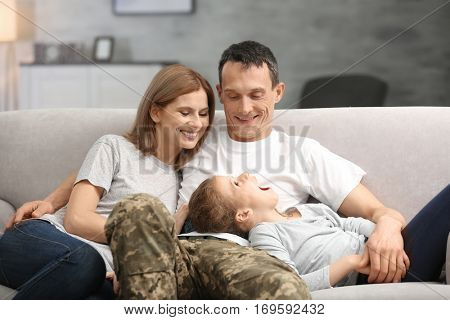 Military father with his family on sofa at home