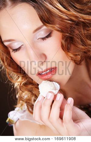 beauty portrait of a cute  girl in act to eat a candy with cocoanut