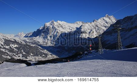 Ski cable car and snow covered mountains Finsteraarhorn and Schreckhorn. Skiing day in Grindelwald Switzerland.
