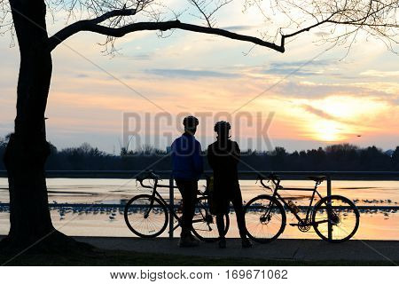 Silhouettes of couple watching sunset at Jefferson memorial - Washington DC USA