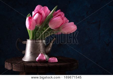 Fresh Pink Tulip Flowers Bouquet In Old Teapot With Chocolate Heart.