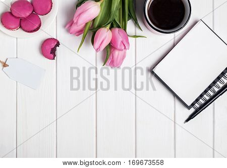 Pink Tulips, Macarons, Empty Notepad And Coffee On White Wooden Table.
