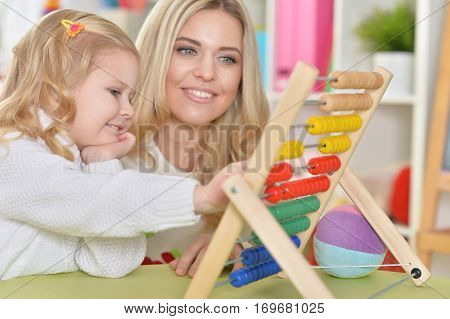 mother with little daughter counting on counter