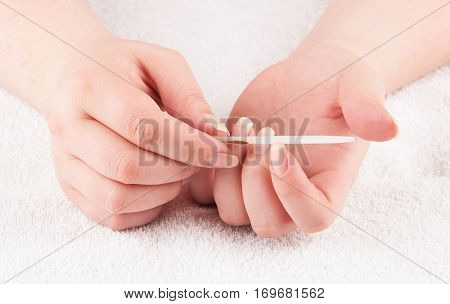 Woman using nailfile during making menicure herself