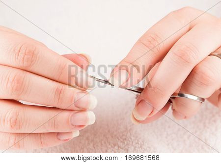Woman making treatment of nail cuticle during manicure
