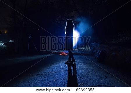 blue backlight girl silhouette in the street night