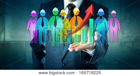 Business man holding a group of worker icons and an exponential growth trend graph in the open palm of his left hand. Concept for multi-ethnic teamwork service solution and motivation management.