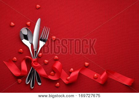 Fork knife spoon with ribbon on red