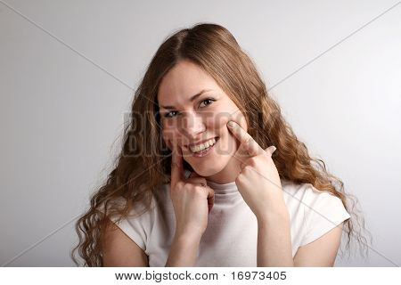 Ragazza che si estende il suo sorriso con le dita