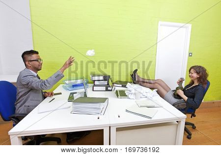 Colleagues throwing crumpled paper to each other