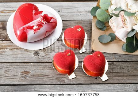 Red heart cacke desserts and buttercups on wooden background. dessert for breakfast on Valentine's Day.