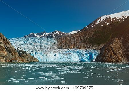 Blue glacier in mountain landscape. Travel destination in Alaska. Tracy Arm glacier tour