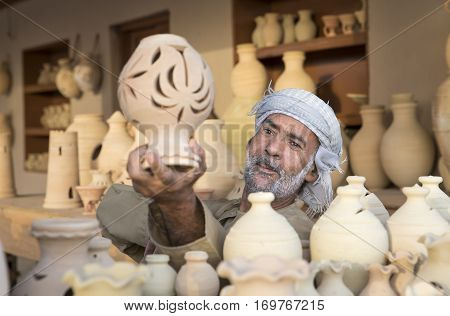 Muscat Oman February 4th 2017: omani man selling clay jars