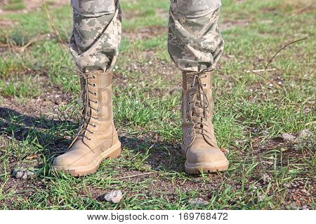 Feet of soldier standing at military firing range, close up view
