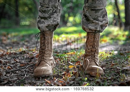 Feet of soldier standing in forest, close up view
