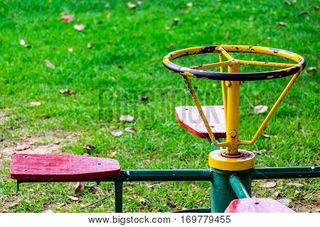 Old carousel for children 4 seats in the playground front focus blurred background